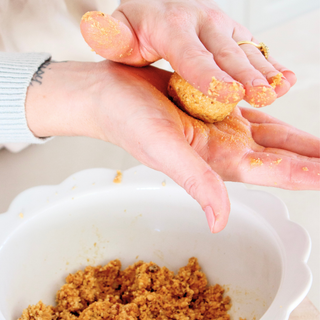 Rolling Sneaky Wholefoods Peaches and Cream Protein Ball Mix into protein balls, a quick and nutritious snack option that is gluten-free, plant-based, and high in protein.