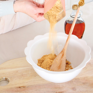 Sneaky Wholefoods Peaches and Cream Protein Ball Mix being poured into a bowl, showing the natural ingredients used to create a high-protein, gluten-free, plant-based snack.