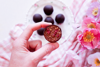 Half bitten Raspberry and peanut butter choc fudge protein ball 