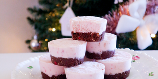 Mini no-bake berry brownie cheesecake cups with fresh strawberries and raspberries on top, set in silicone muffin molds, showing a creamy, fudgy dessert perfect for snacks or treats