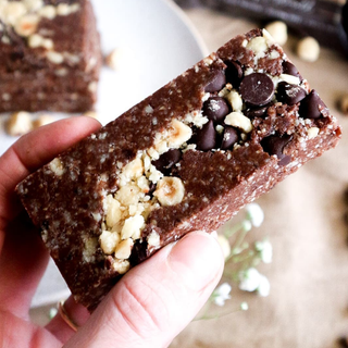 Hazelnut Protein Bar unwrapped showing dark chocolate chips and crushed hazelnuts on top 