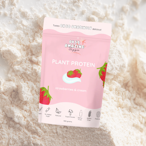 Pink package of 'Oh So Amazing' plant protein with strawberries and cream flavor on a white powdery background.