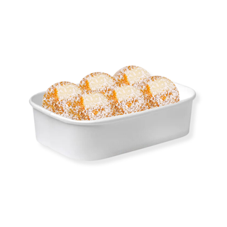 Pumpkin Pie Protein Balls in a white container showing chunks of white chocolate chips coated in coconut 