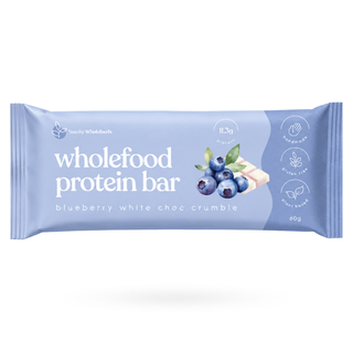 A packaged wholefood protein bar from Sneaky Wholefoods, flavour blueberry white choc crumble, in a light blue wrapper with white text and an illustration of blueberries and a chocolate piece.