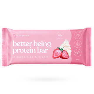 A pink wrapper for a Better Being Protein Bar in strawberries & cream flavour, featuring illustrations of strawberries and a swirl of cream, on a white background.