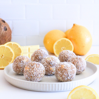 Platter of lemon balls with lemons on a white background