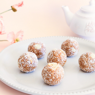 Gluten Free Carrot Cake Protein Balls on a white plate with a blurred background