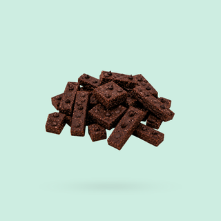 A pile of mint brownie sneaky seconds, floating against a solid pale mint green background.