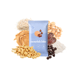 A single packet of 'nourish bite' peanut butter cookie centered on a white background, surrounded by its ingredients: peanut butter, cashews, chocolate chips, dates, and peanuts