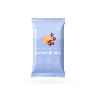 A single packet of 'nourish bite' peanut butter cookie on a solid white background. The packaging is a light pastel blue with white text and a graphic of a peanut butter cookie and chocolate pieces.