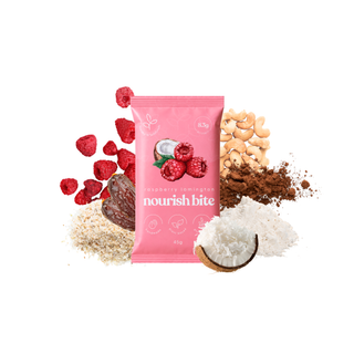 A pink pouch of a raspberry lamington nourish bite protein powder centered on a white background, surrounded by ingredient piles including raspberries, cashews, cocoa powder, and coconut.