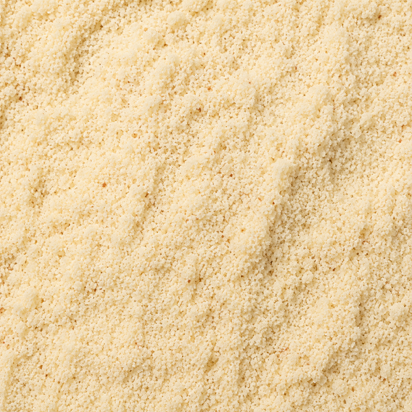 A close-up texture shot of a fine, granular beige almond meal, filling the entire frame.