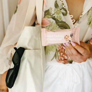 Close-up of a Sneaky Wholefoods Vanilla Cookie Dough Protein Bar held in its vibrant packaging, highlighting its tempting cookie dough flavour and wholesome ingredients