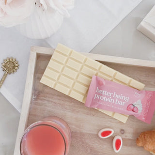 Relaxed video of two friends enjoying Sneaky Wholefoods Strawberries and Cream Protein Bars during a cheerful morning tea, highlighting their vibrant pink color and creamy flavor while showcasing a wholesome way to nourish friendships and fuel active lifestyles