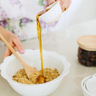Lemon cheesecake Protein Balls being made in a kitchen using mix and syrup and rolling them together 