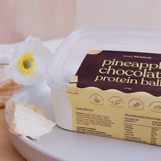 Pineapple Chocolate Protein Balls packet opening up to uncover the protein balls 