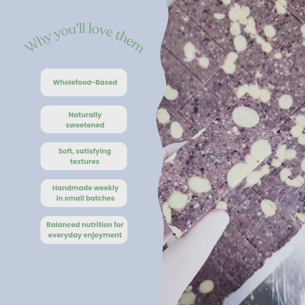Video showcasing Sneaky Wholefoods blueberry white choc crumble and apple white choc pie protein bars in a production setting, switching between different flavours while highlighting key features including wholefood-based ingredients, naturally sweetened, soft satisfying textures, handmade weekly in small batches, and balanced nutrition for everyday enjoyment.