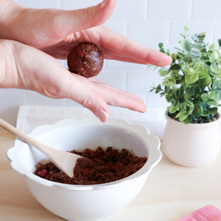 Raspberry Fudge Brownie Protein Ball Mix being rolled into balls – a quick and easy way to make healthy, high-protein, gluten-free snacks.